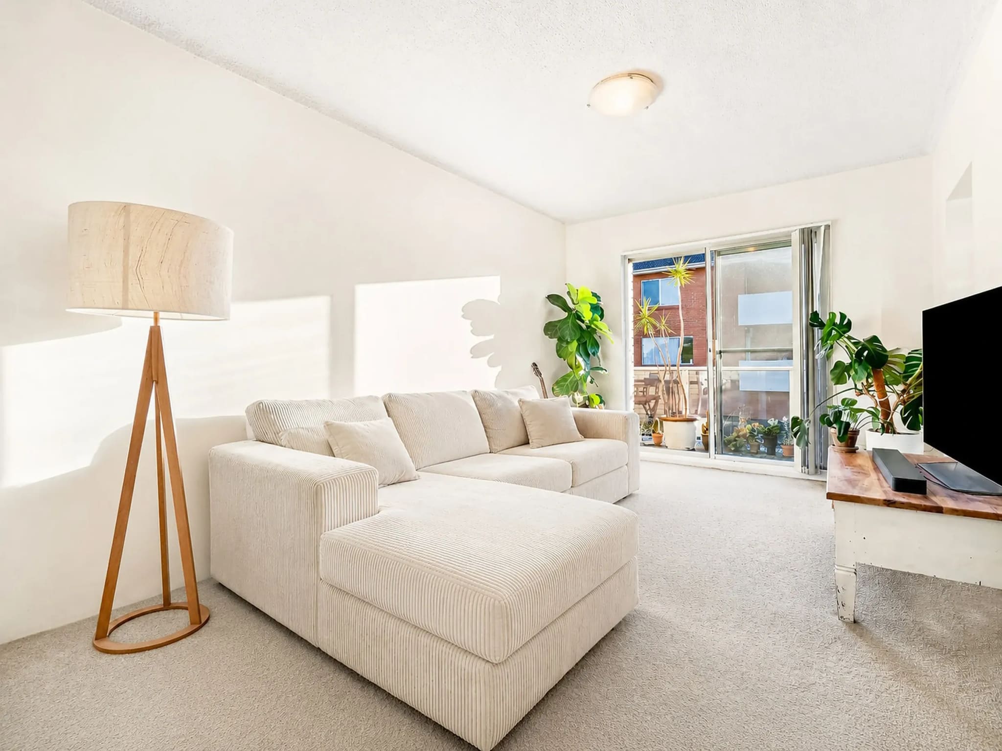 Lounge room with a corner sofa and sliding doors to a balcony, Freshwater