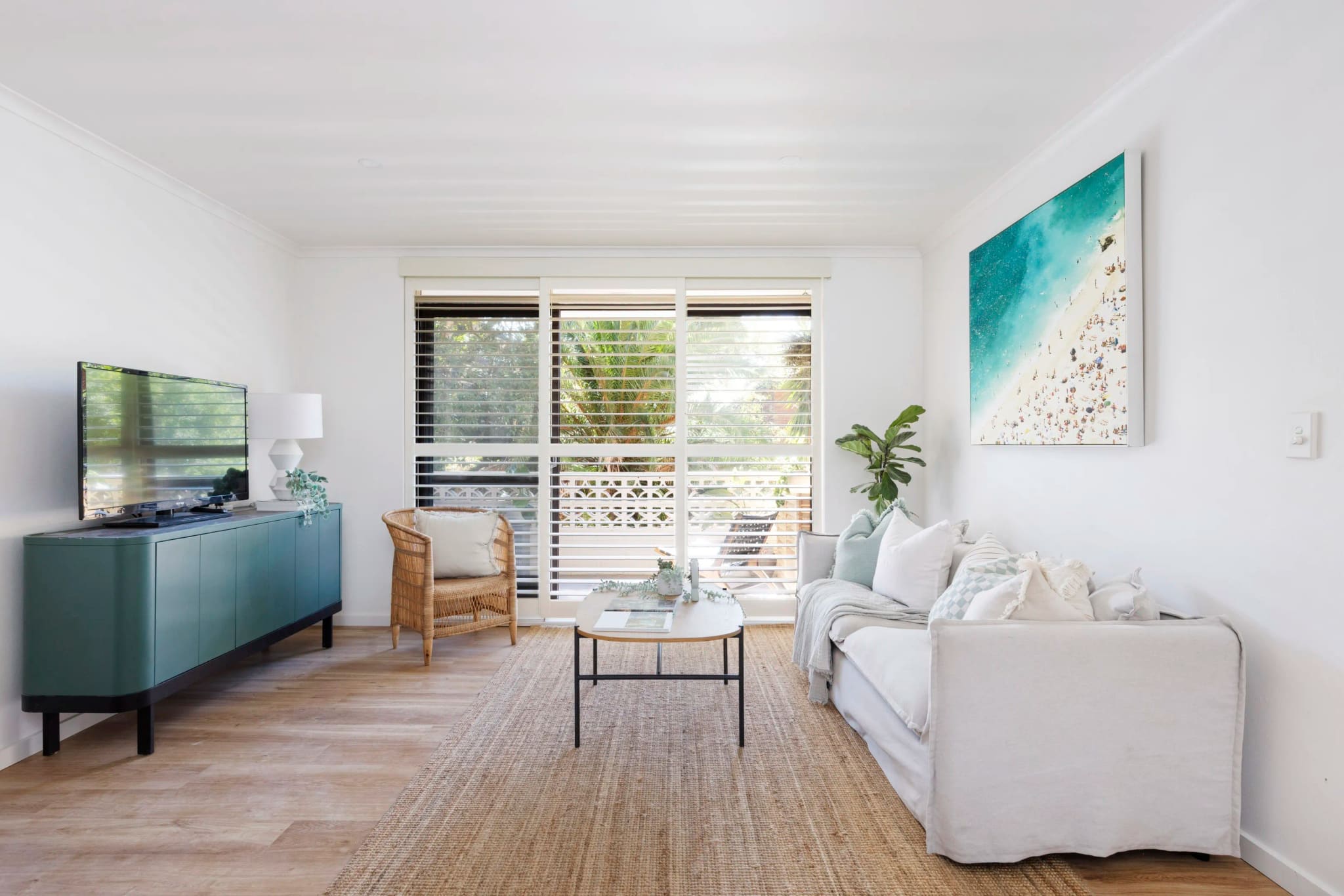 Living room with timber floors, a low sideboard and a framed coastal print, Manly Vale