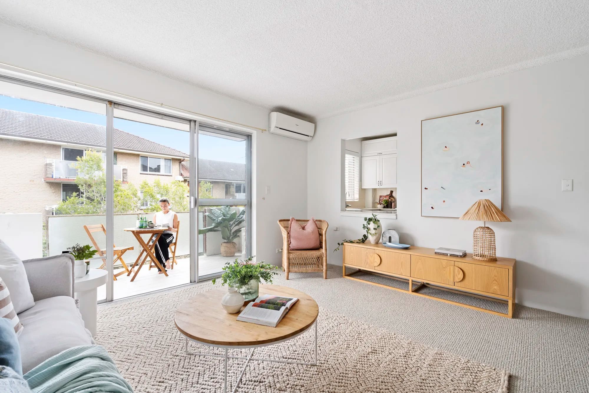 Lounge room opening through sliding doors to a planted balcony, Manly Vale
